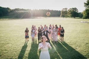 Photo de lancer de bouquet pendant le cocktail de mariage